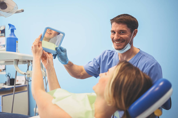 stock photo dentist shows patient results treatment mirror examinating teeth dental equipment